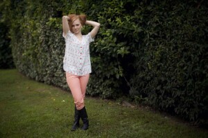 A light blue Aida top with pink feathers worn with pink pants