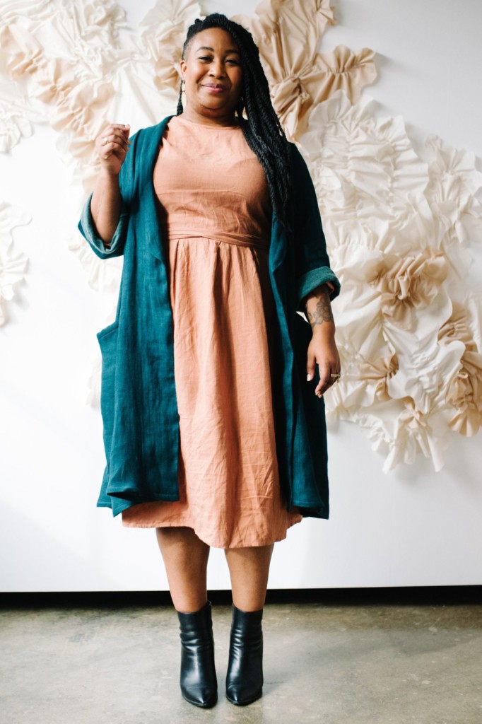 Ashley wears a peach dress and a blue Lichen Duster