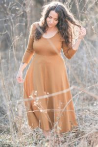 Meg McElwee wearing a mustard Stasia Dress in a golden-colored field