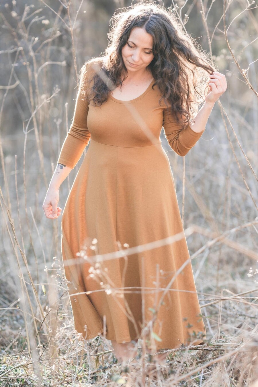 Meg McElwee wearing a mustard Stasia Dress in a golden-colored field
