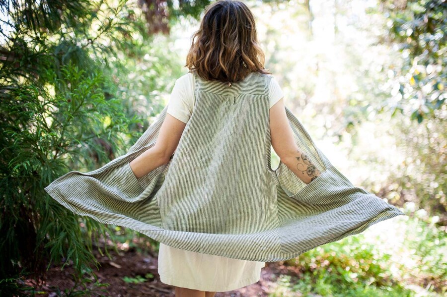 Meg wears a striped Forager Vest over a white Hinterland Dress
