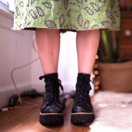Meg's legs sticking out of a green skirt
