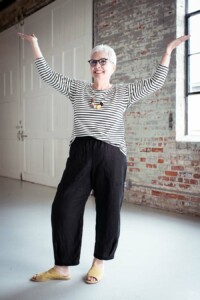 Cindy wears black chanterelle pants and a striped top