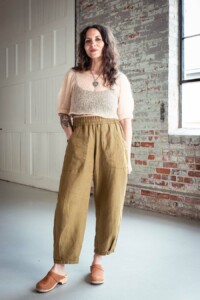 Meg wears olive chanterelle pants and a fuzzy cream top