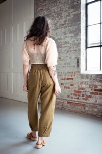 Meg wears olive chanterelle pants and a fuzzy cream top
