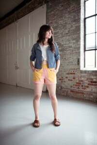 Meredith wears pink and yellow color blocked chanterelle shorts and chambray joanie top