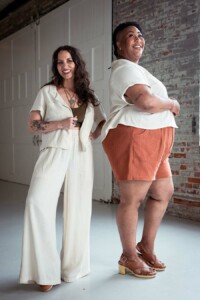 Meg wearing cream view a chanterelle pants and. cream jonie top over an olive tank and Ashley wearing red chanterelle shorts and a cream Joanie Top