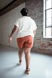 Ashley wearing red chanterelle shorts and a cream Joanie top