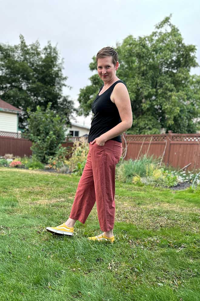 Judith wears a black top and red straight leg chanterelle pants